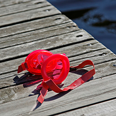 Ett par röda simglasögon som ligger på en brygga på Framnäsbadet. Foto: Pressbild
