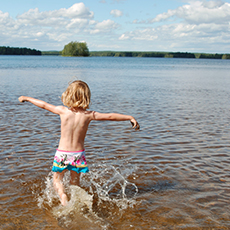 En pojke som springer ut i vattnet på Sundängens Badplats. Foto: Pressbild