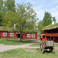Bilden visar små röda hus med en gammal vagn. Fotograf Nina larsen Welander