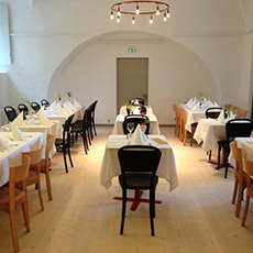 Bild beskriver en sal med flera bord med vita dukar och fin dukning