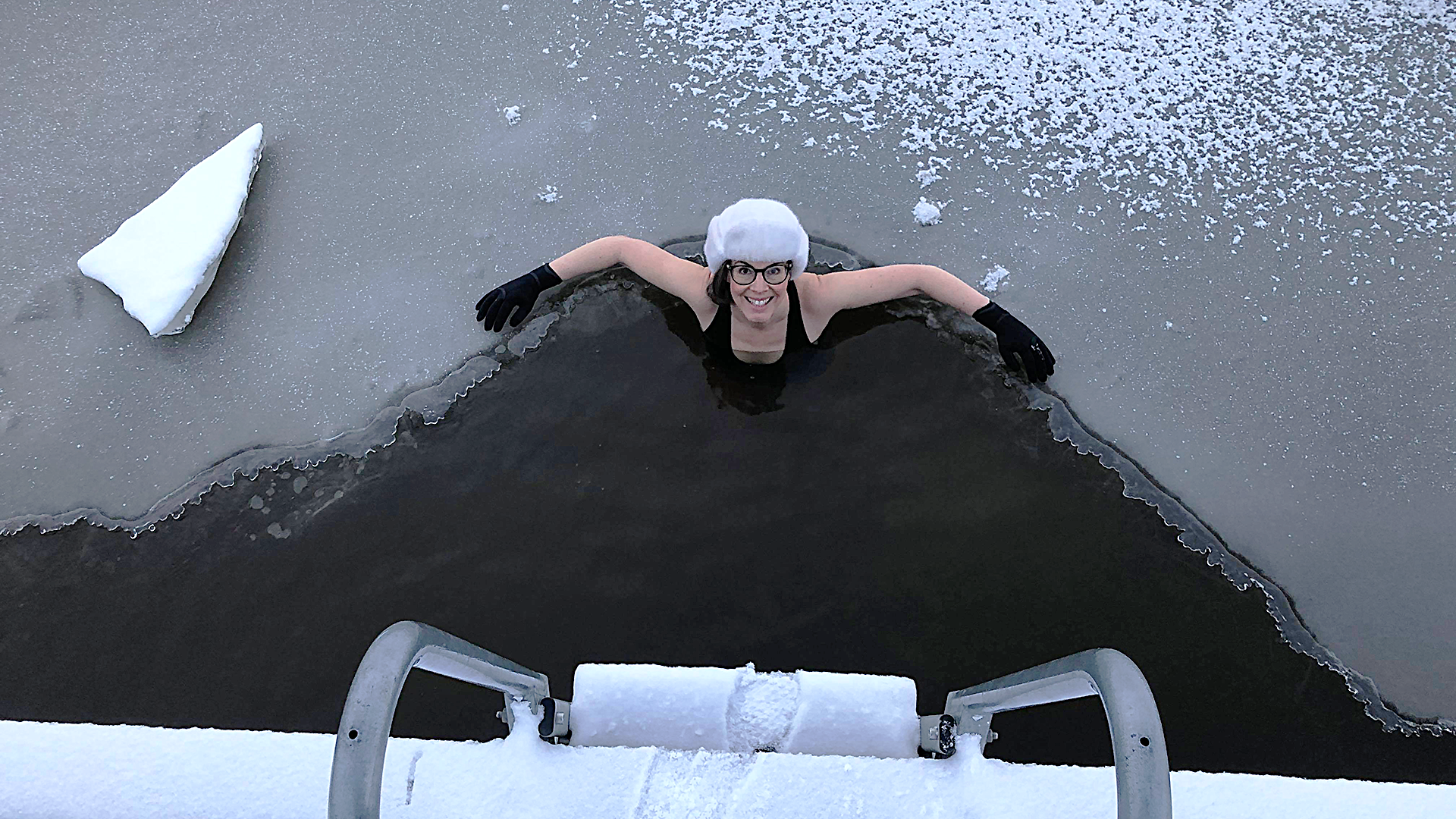 Kvinna med pälsmössa badar isvak. Foto: Pressbild