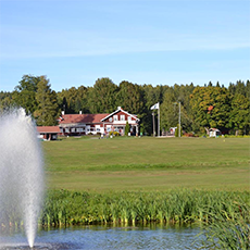 Vy över Fagersta golfklubbs klubbhus med fontän i förgrunden. Foto: Pressbild