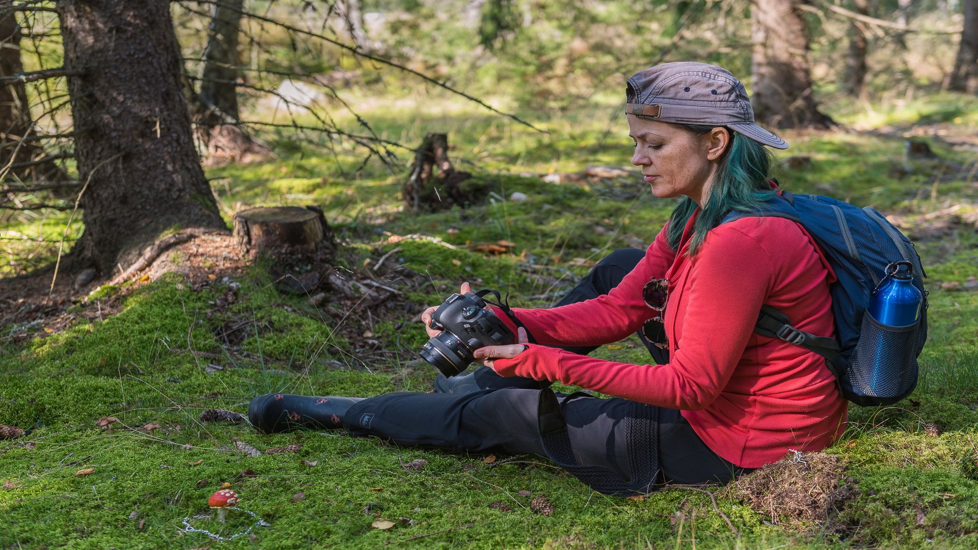 En kvinna sitter i skogen med kamerautrustning. Fotograf: Pressbild