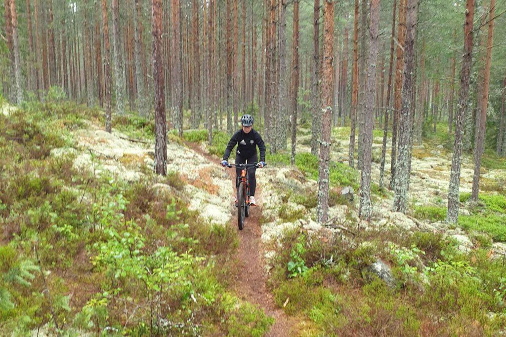 En flicka cyklar i skogen. Fotograf: Pernilla Wester