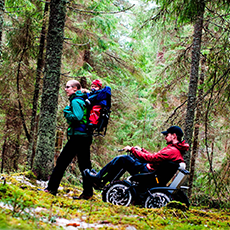 Familj vandrar i skogen, till fots och med terrängfordonet Zoom Uphill. Pressbild